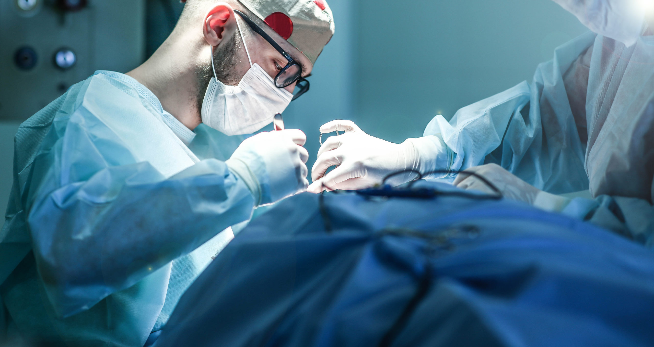 Young male plastic surgeon operates in the operating room of a medical center.